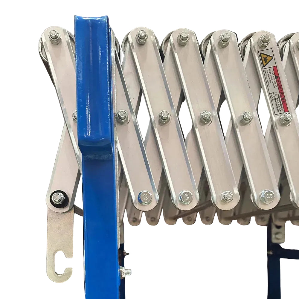 Close-up of a blue metal conveyor mechanism with bolts and warning label.
