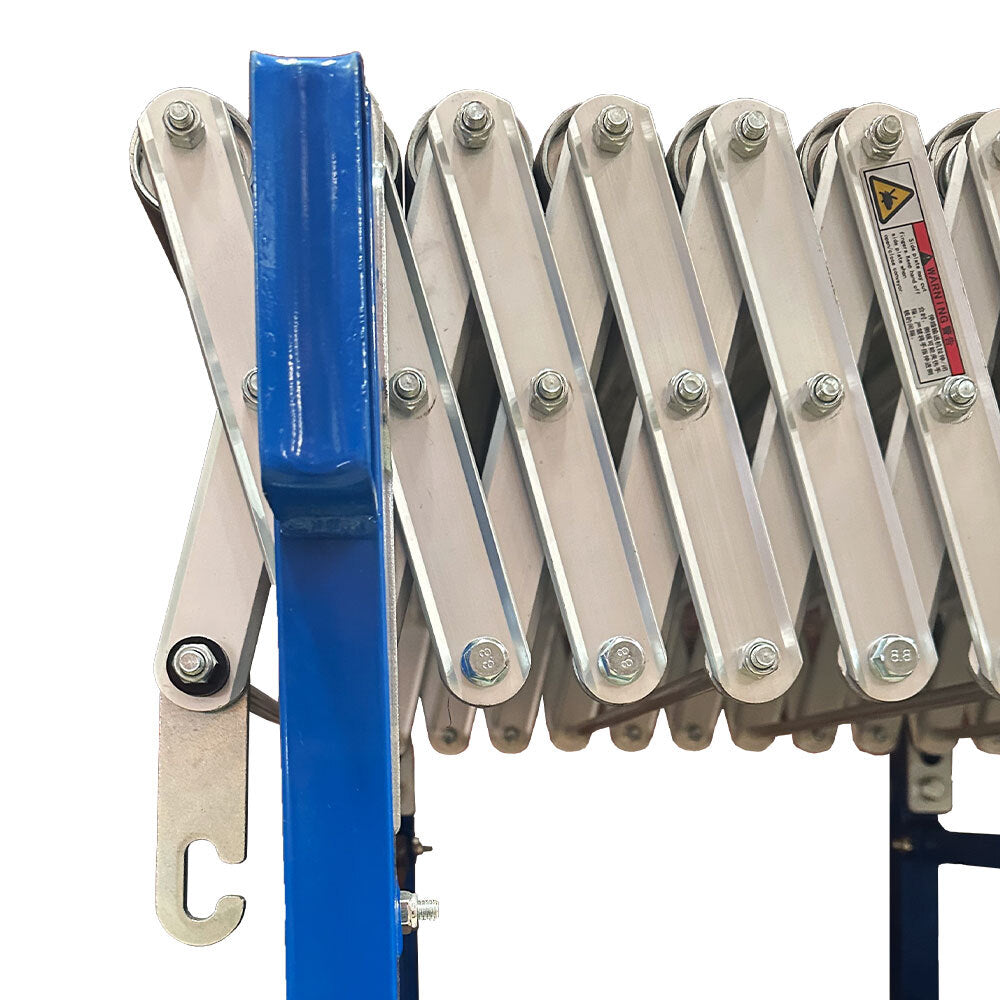 Close-up of expandable metal conveyor rollers with a blue frame and warning label.
