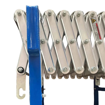 Close-up of a blue metal conveyor mechanism with bolts and warning label.