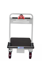 Back view of a motorized platform cart with a black flatbed, silver handle, red emergency stop button, and visible wheels.