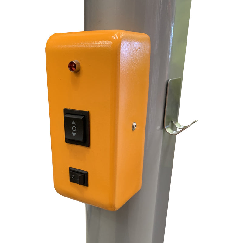 Close-up of a bright orange control box featuring an up/down switch, a power button, and a status indicator light, mounted on a metal pole.