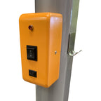 Close-up of a bright orange control box featuring an up/down switch, a power button, and a status indicator light, mounted on a metal pole.