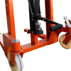 Close-up of an orange pallet stacker's base with 2 wheels, foot pedal, and hydraulic mechanism.