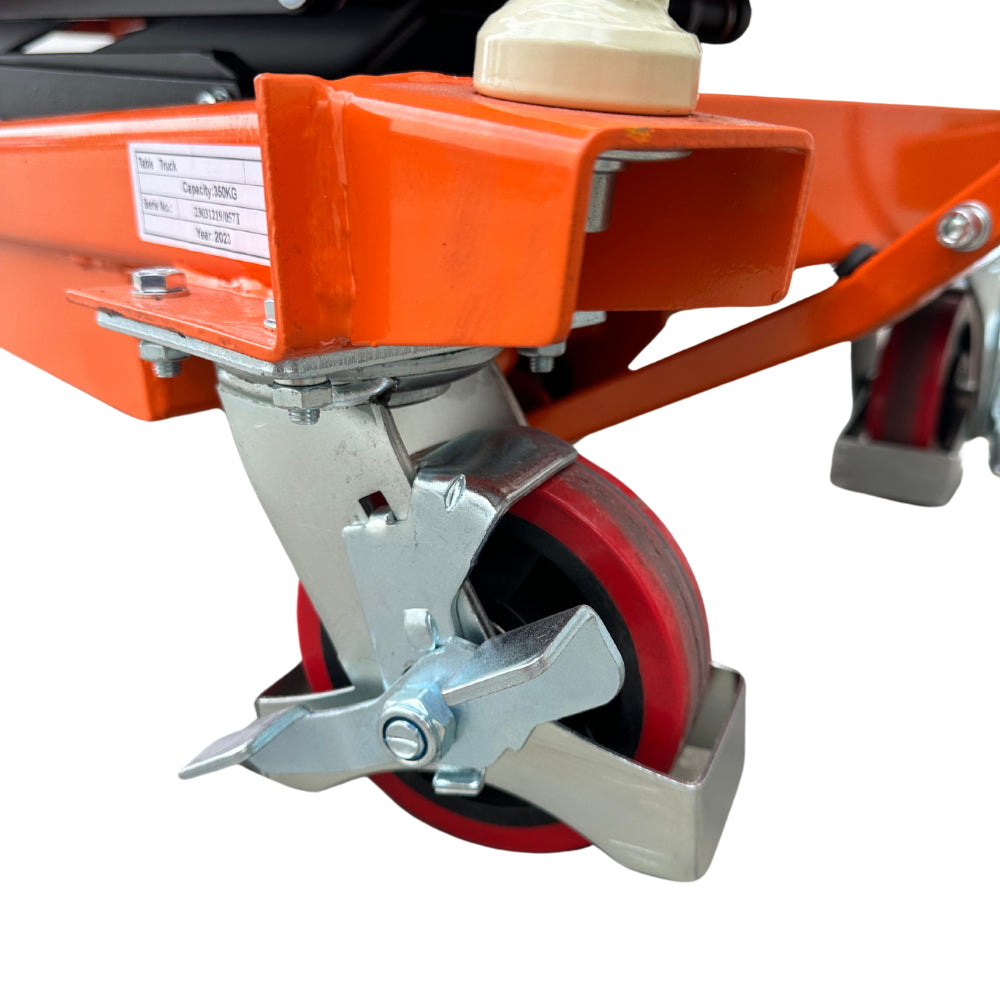 Close-up of a sturdy orange lift with a metallic wheel assembly, showcasing its locking mechanism and red rubber wheel.