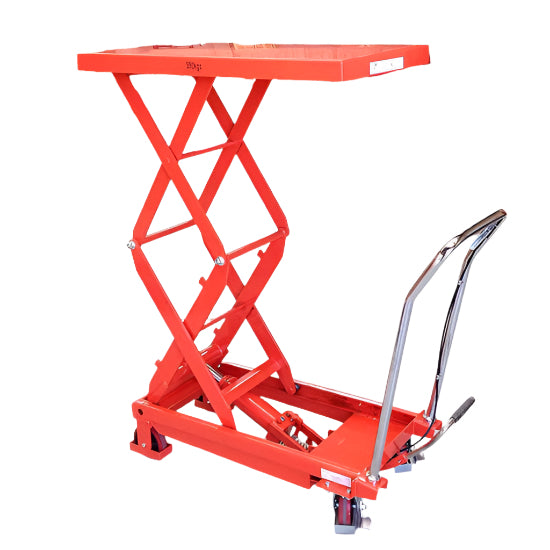 A bright red scissor lift table with a sturdy surface, elevated on a scissor mechanism, featuring a metal handle for operation.