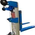 Close-up of a blue manual hand stacker device with wheels, a handle, and forks, designed for transporting heavy items.